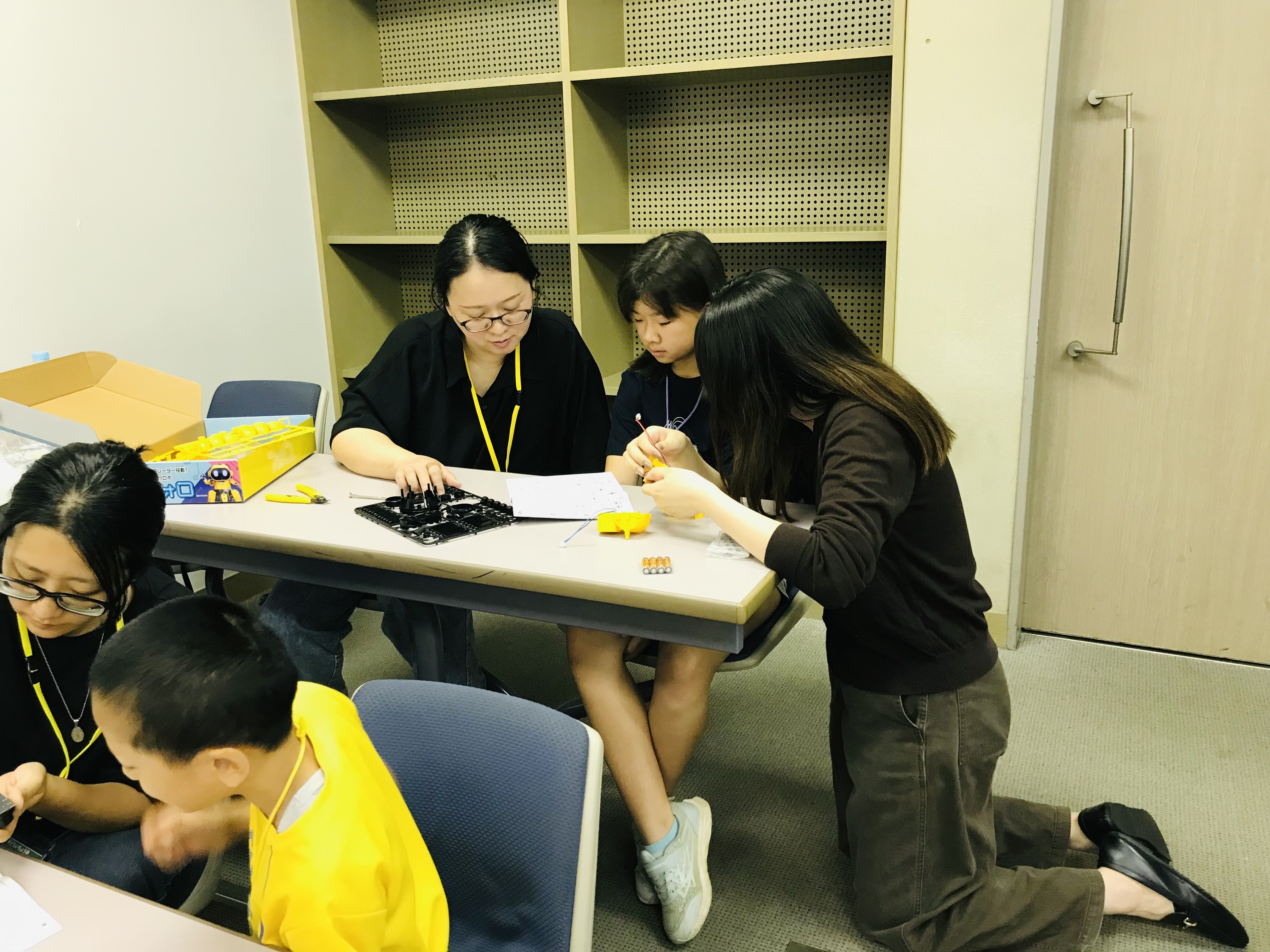 学生スタッフと保護者が子どもの組み立てをサポートする様子