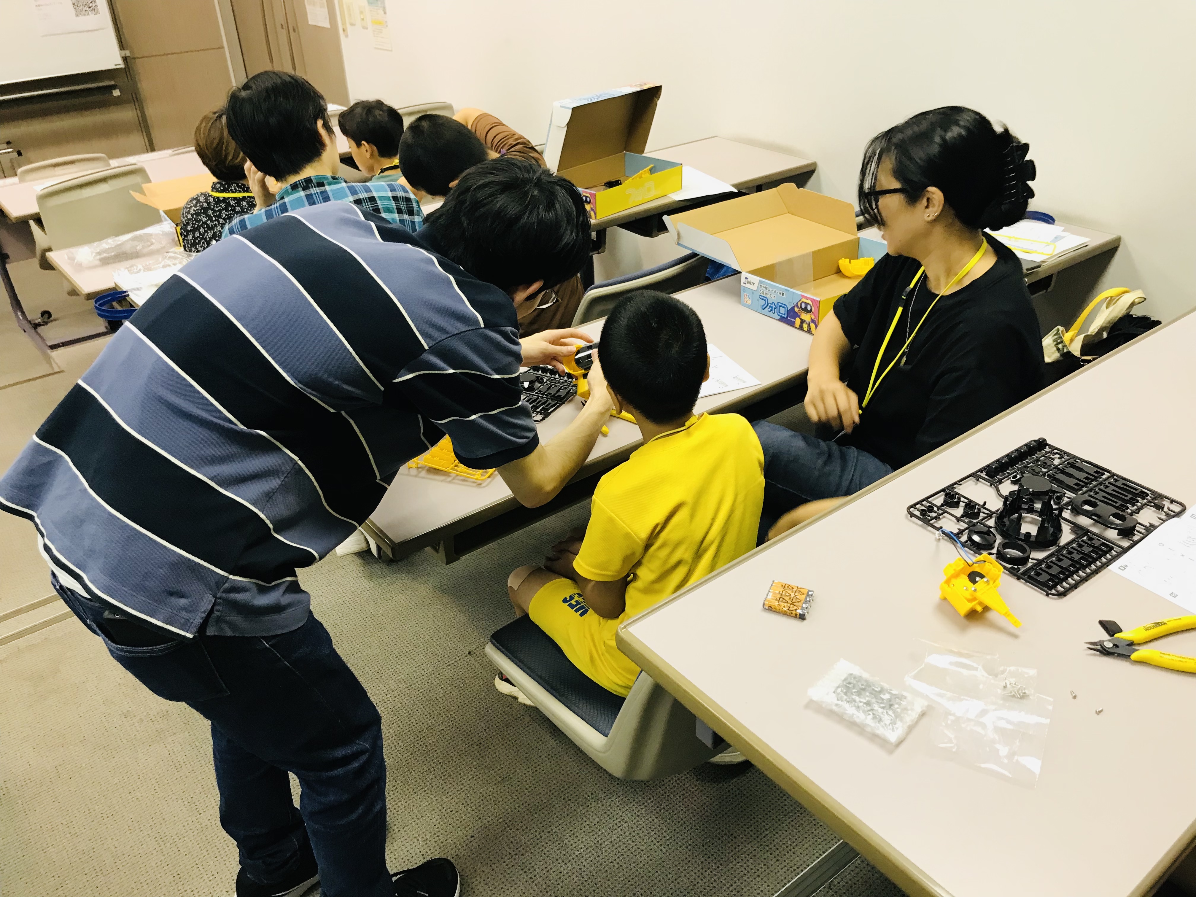 学生スタッフが子どもの手元の作業を手伝う様子